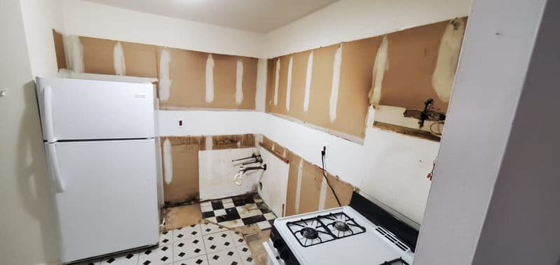 A kitchen part-way through demolition, with the old units coming out