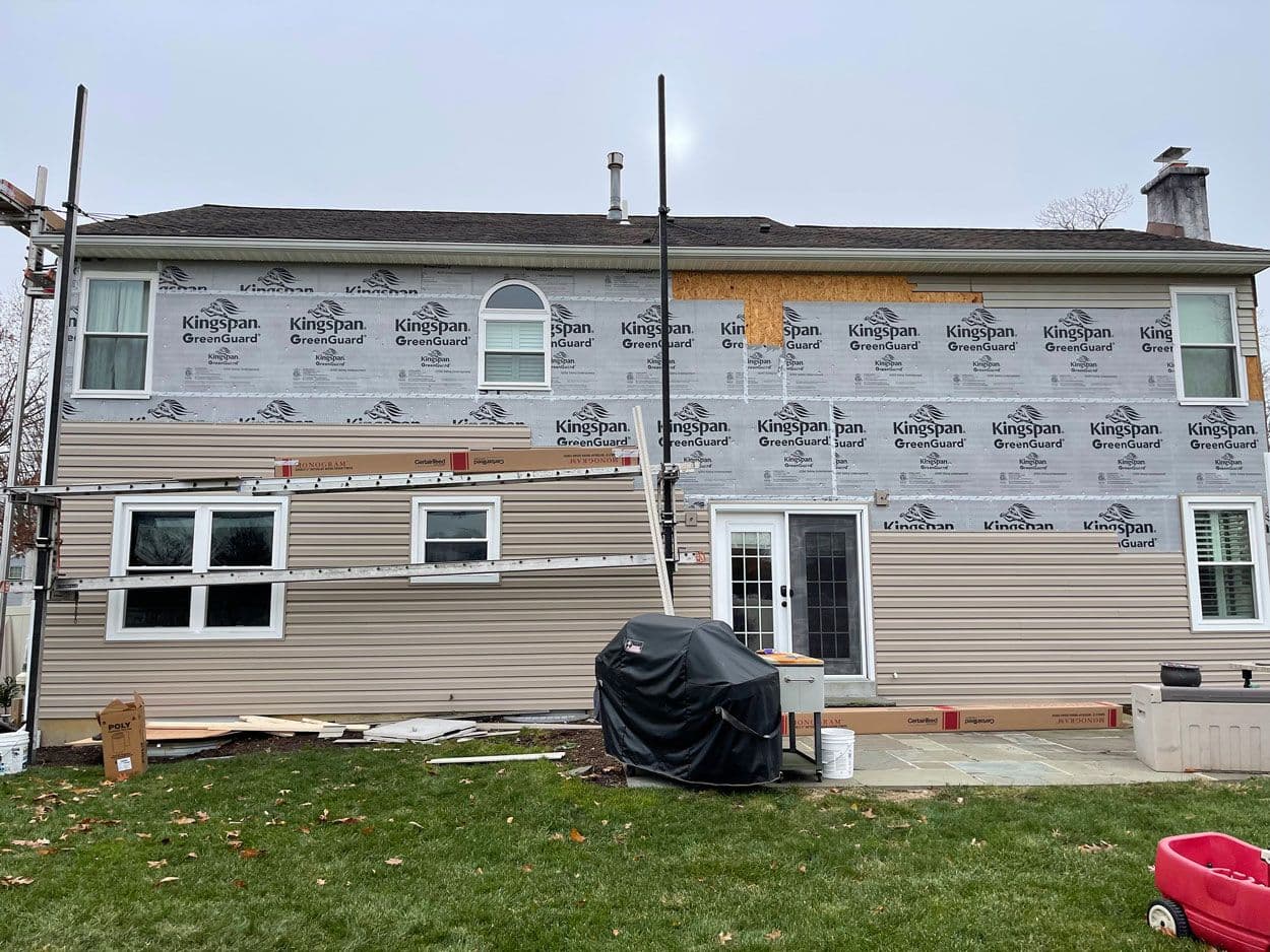 New windows set into a wall wrapped in house wrap, ready for siding